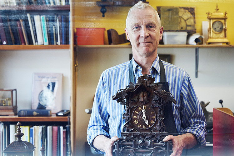Clock Store Owner holding antique clock